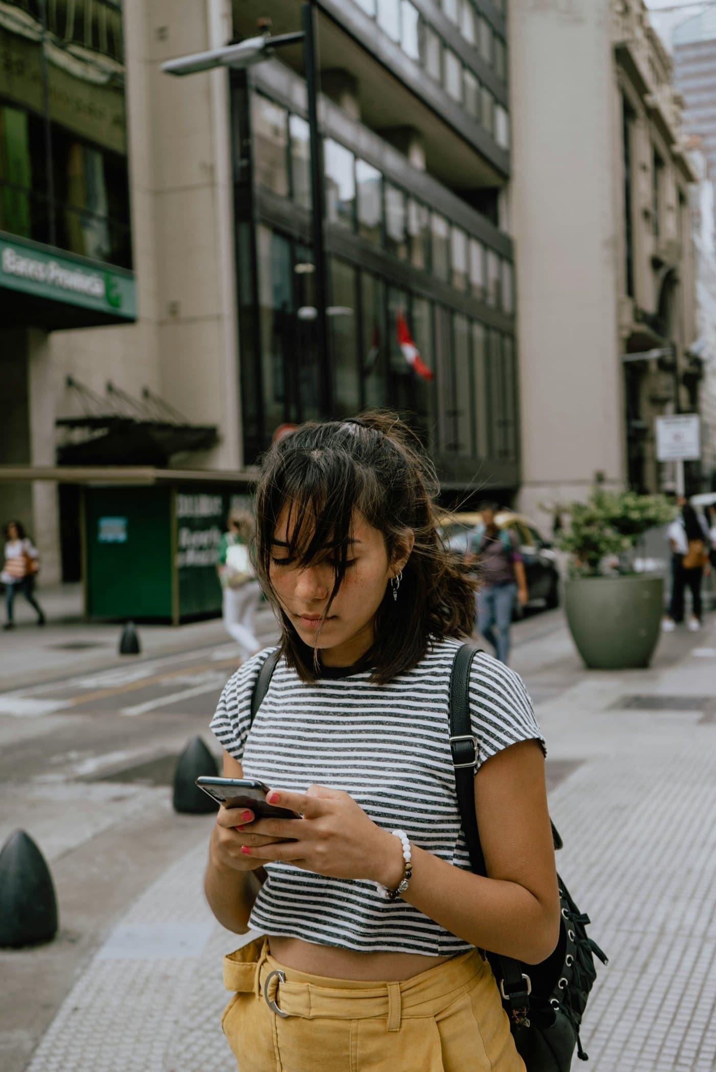 Jovem na rua olhando o celular
